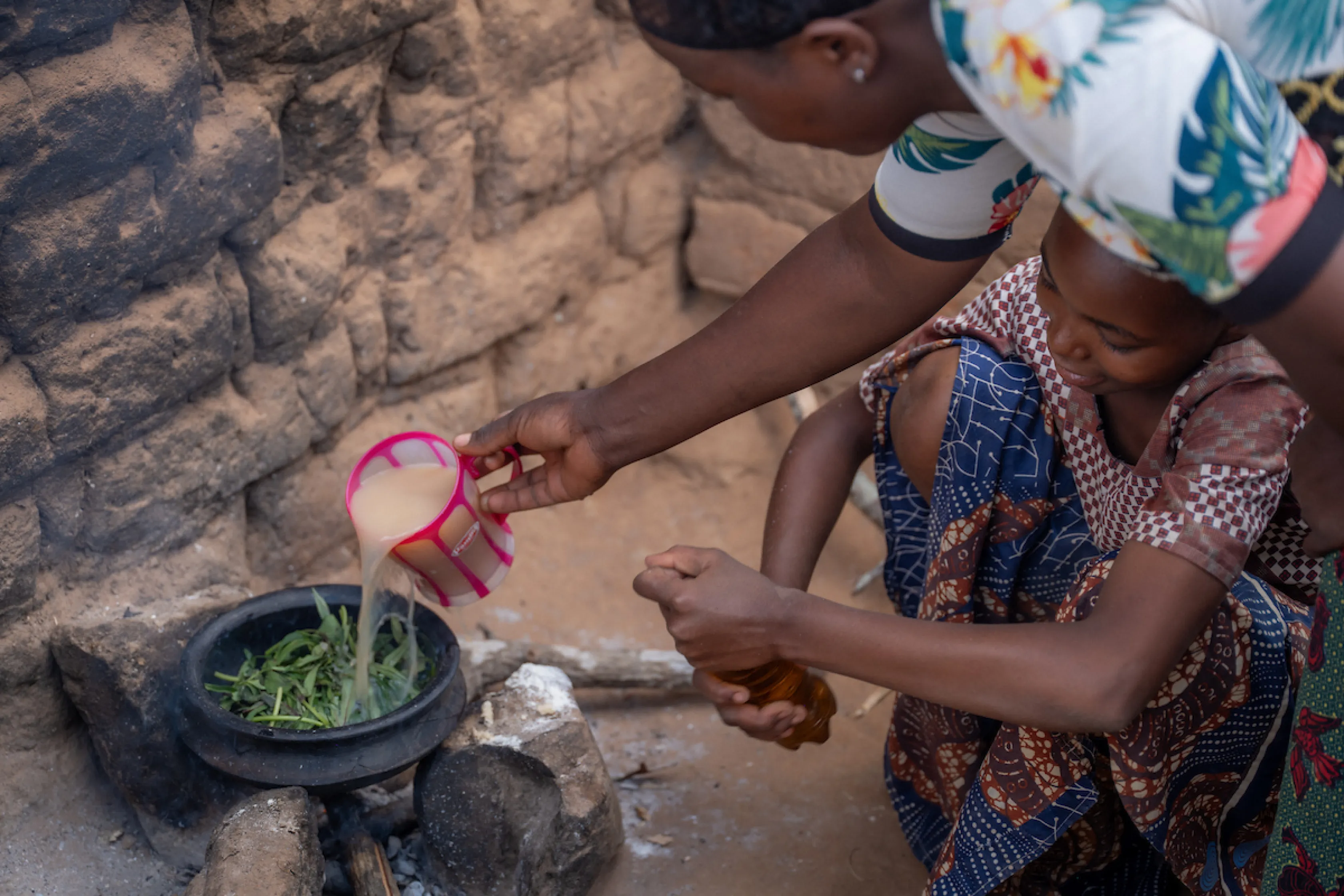Family in Tanzania, Africa cooks with dirty, unsafe water
