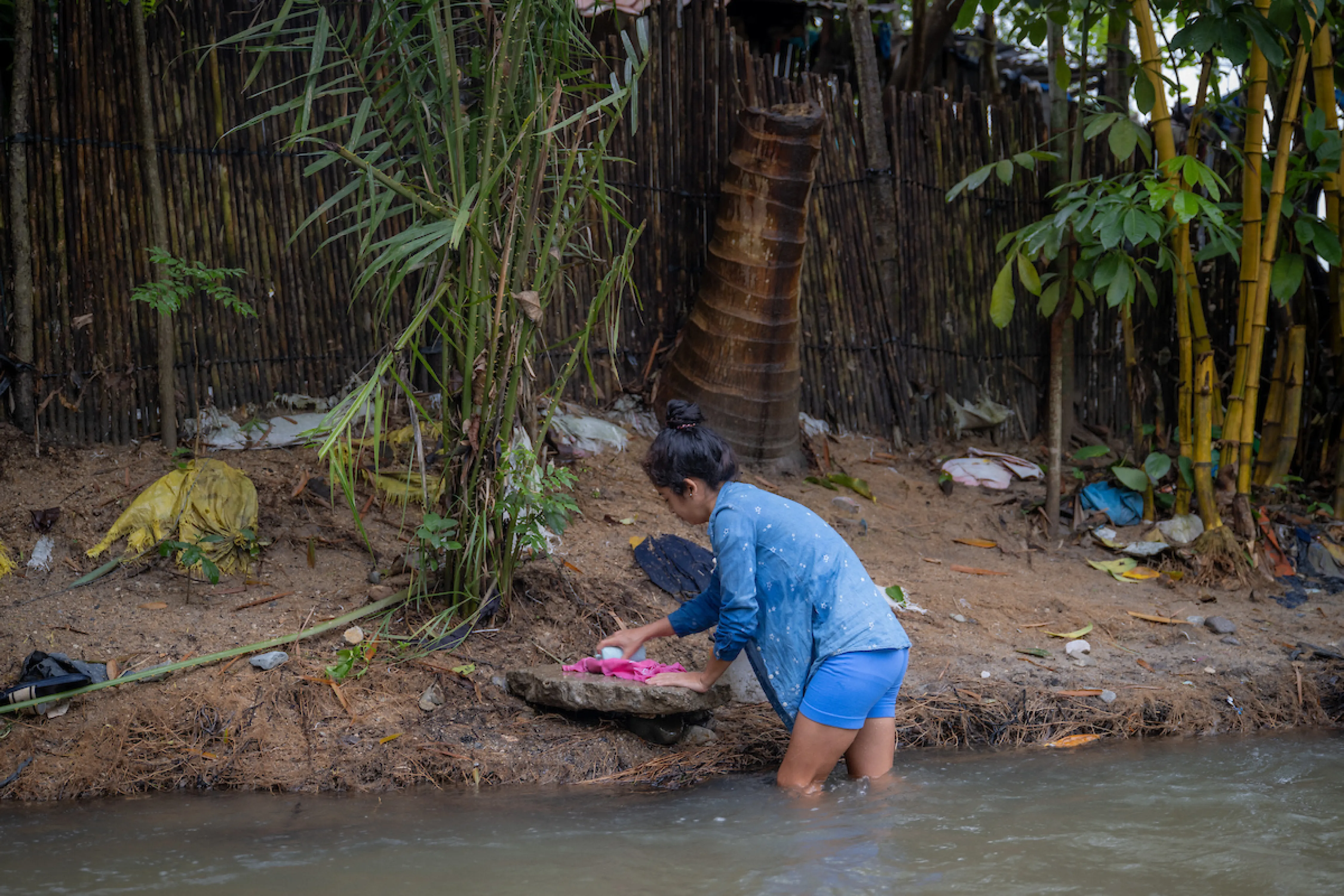 Rosa washes clothes in the river