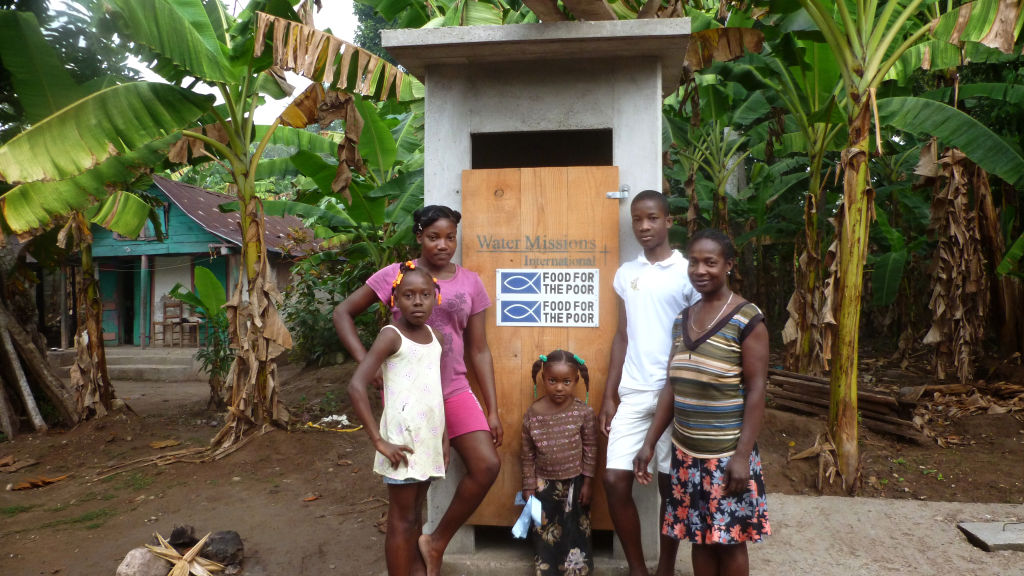 A Haitian family with a latrine