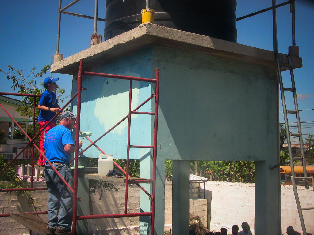 Two guys paint a water tower