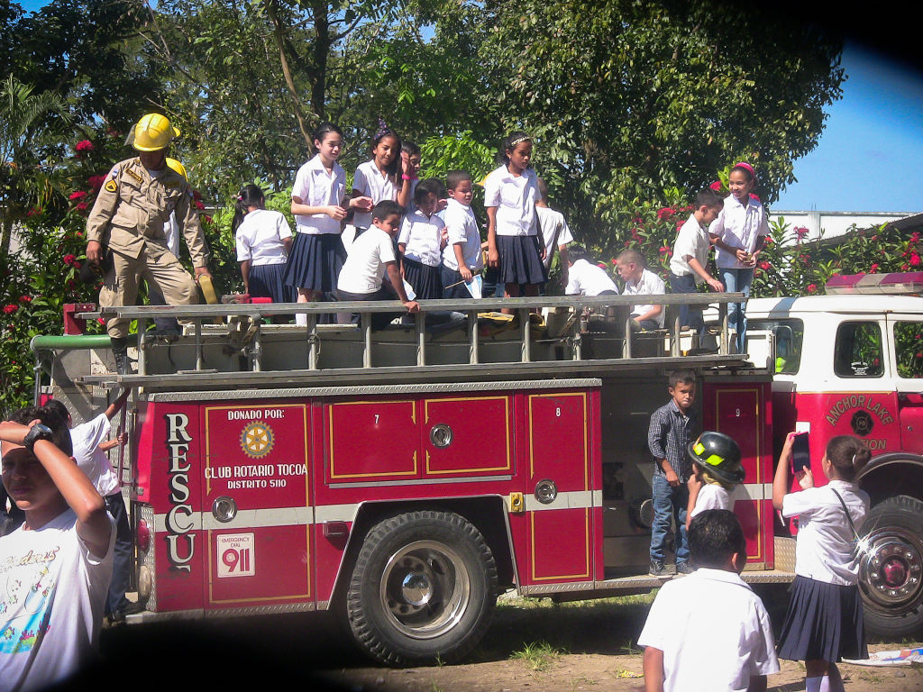 The firetruck serves as entertainment for the school children.