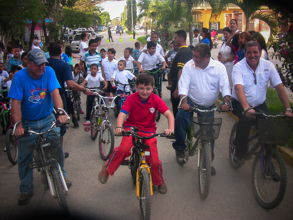 Scotty Parker bikes through a community in Honduras.