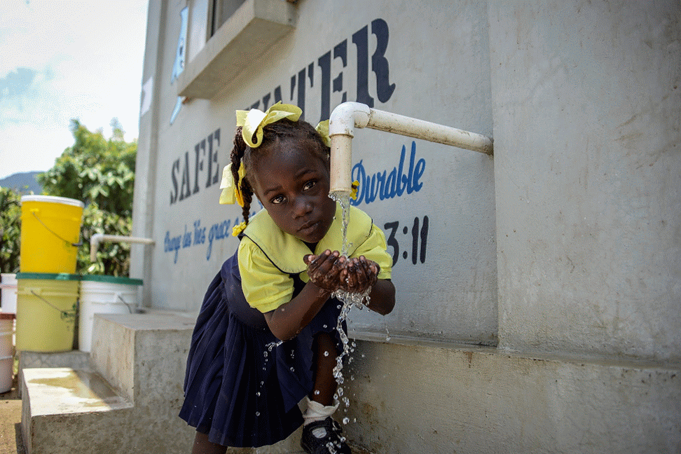 Lidachele drinks safe water by her school in Bois Savanne, Haiti