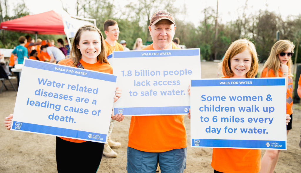 Volunteers hold signs at 10th Annual Charleston Walk for Water