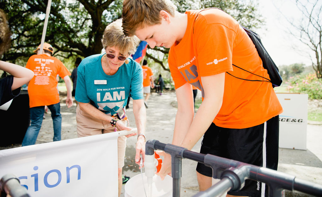 Founder Molly Greene fills up water bucket at a filling station.