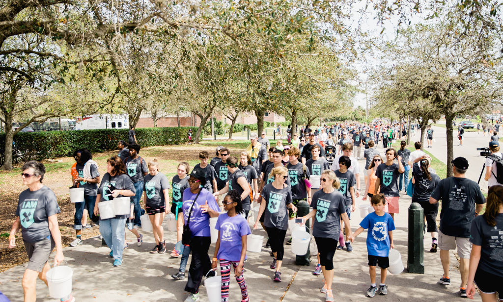Walkers carry filled buckets back to beginning at the Charleston Walk for Water