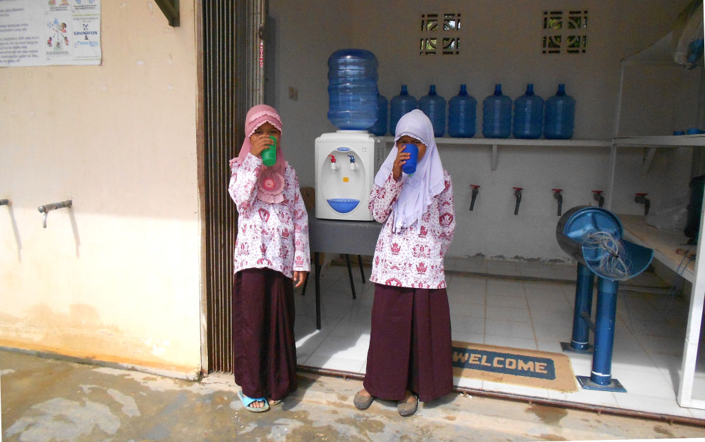 Girls drink safe water in Kulim, Indonesia