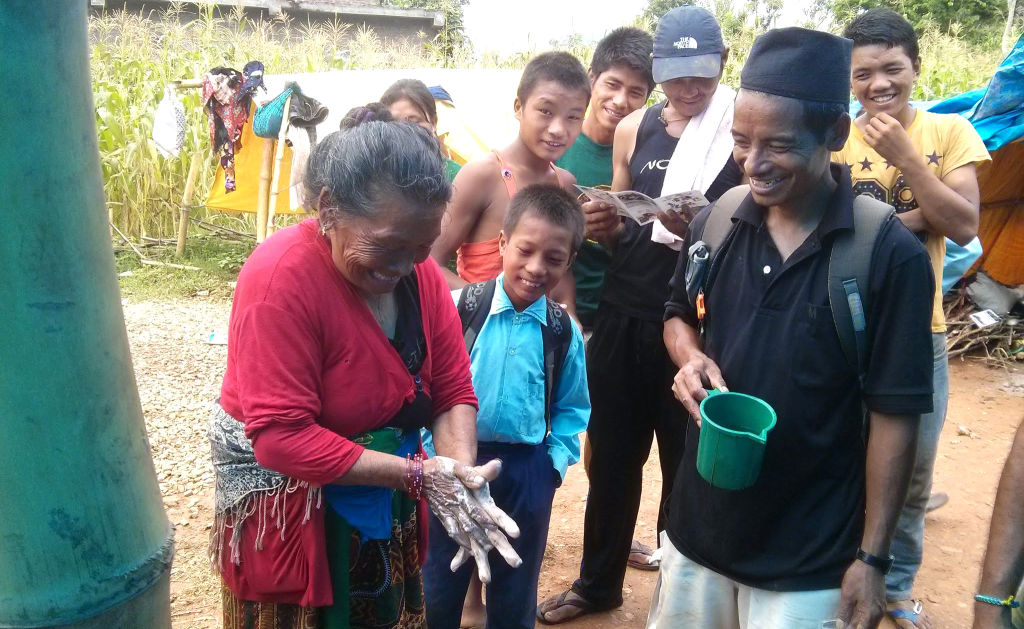 Woman washes hand from WASH training in Nepal