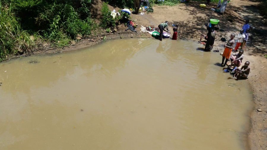 South Sudanese refugees collect dirty water for washing, cooking, and drinking in Uganda.