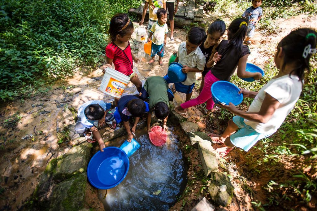 Children in Peru collect dirty water from a hand-dug well.