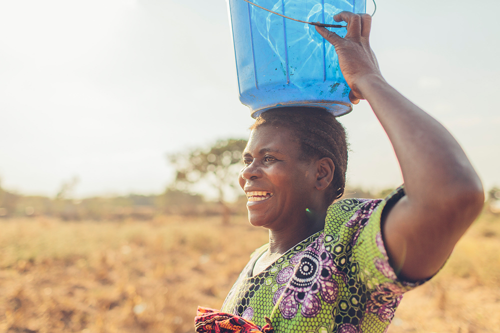 A woman in Malawi smiles because of safe water.