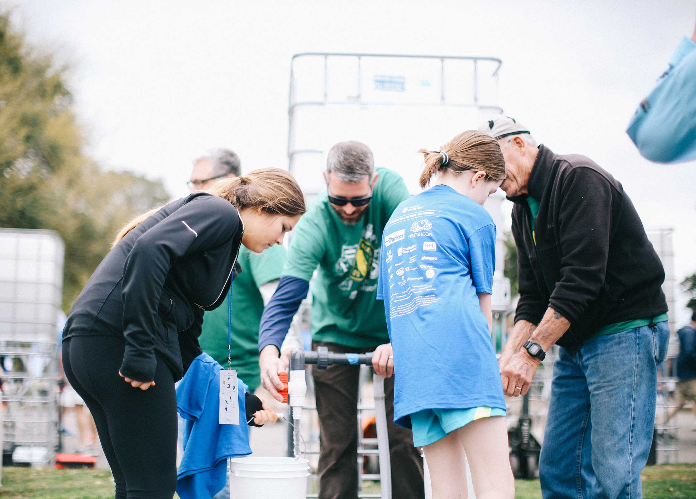 Walkers fill up their buckets with dirty water halfway through the Walk for Water.