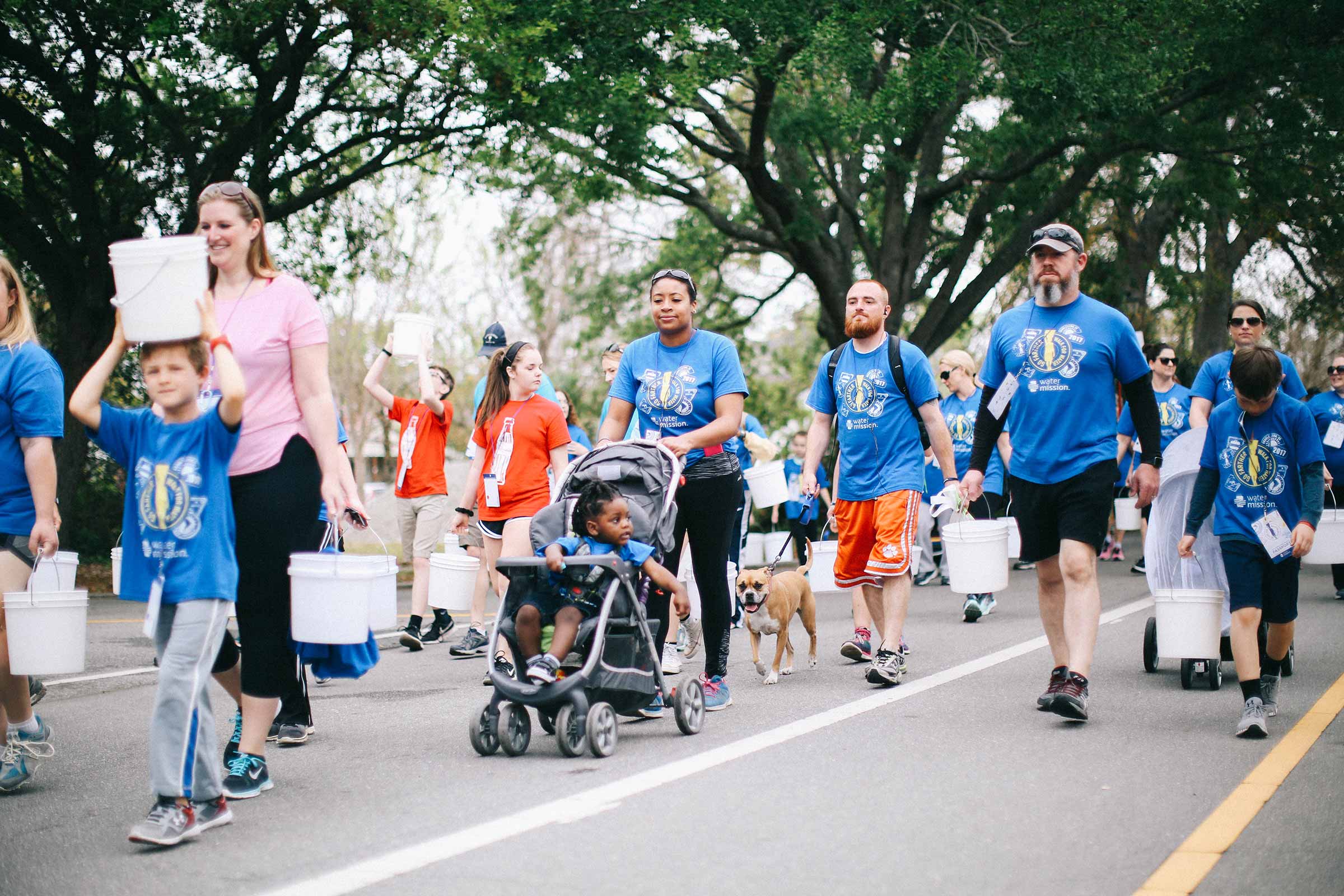 A mother pushes her daughter in a stroller at Water Mission's Walk for Water.