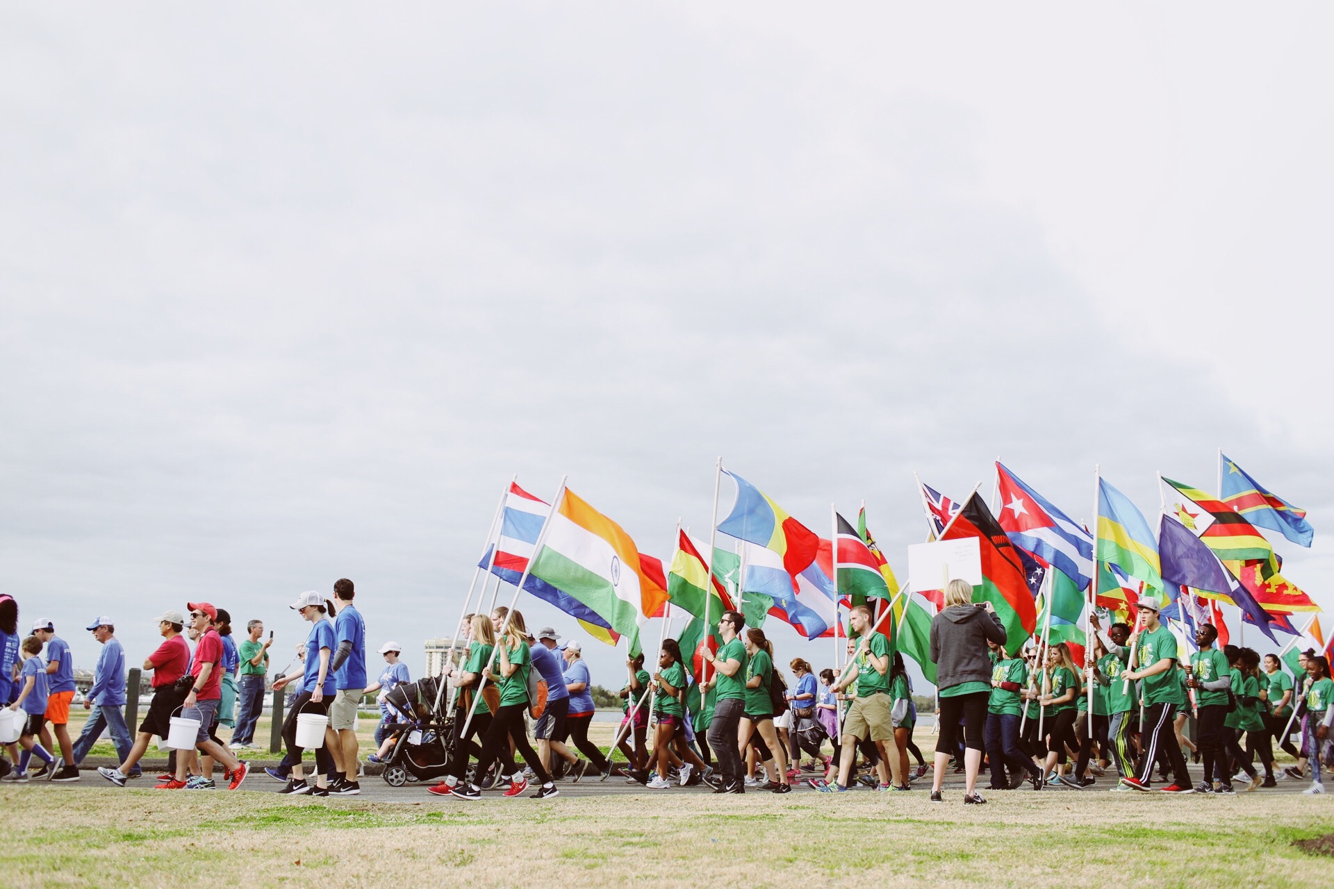 Volunteers carry flags to lead the group of 5,000 walk for water heroes.