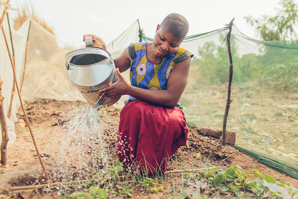 A woman waters her garden which was made possible by the safe water treatment system.A woman waters her garden which was made possible by the safe water treatment system.