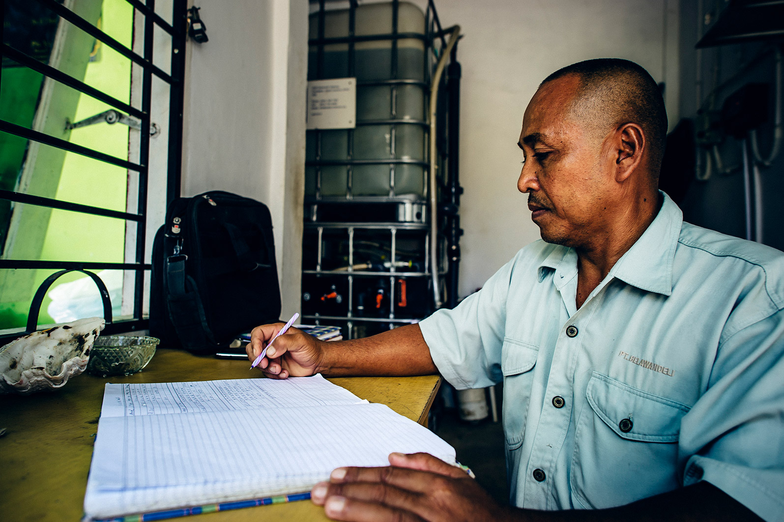 An operator calculates expenses for the safe water treatment system.