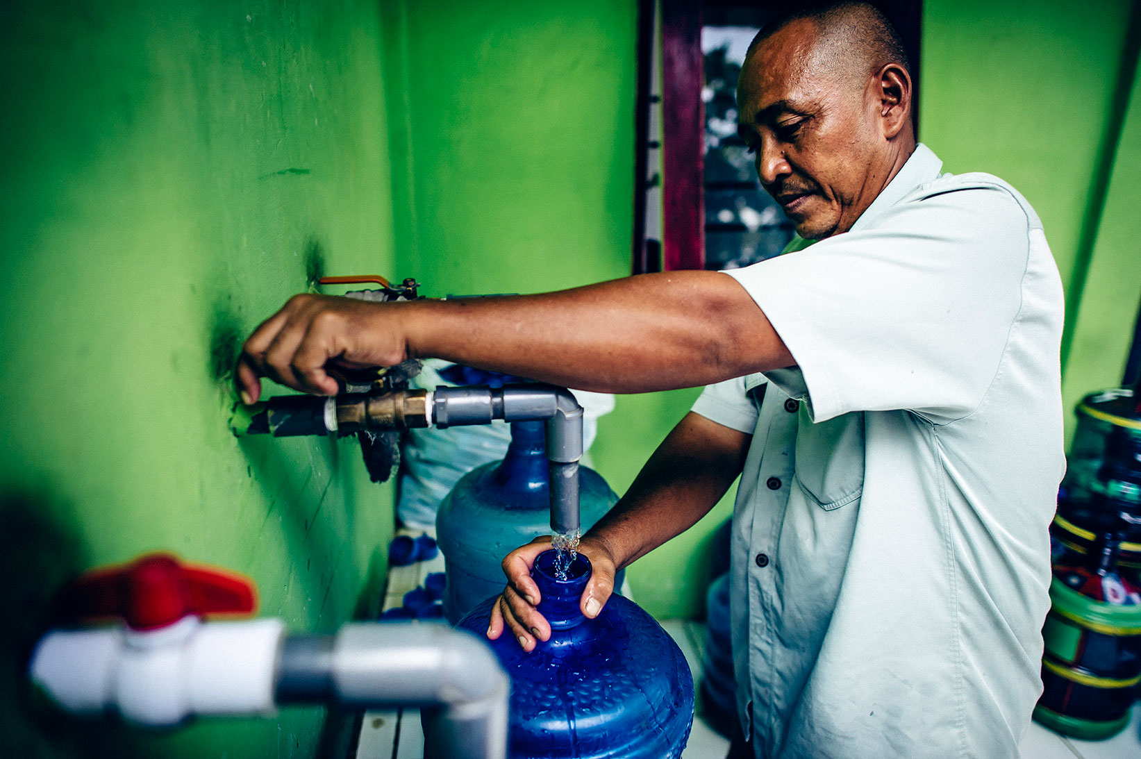 The system operator fills a jug with safe water.