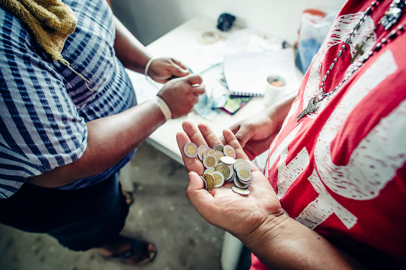 A man pays for water at a Water Mission safe water treatment facility.