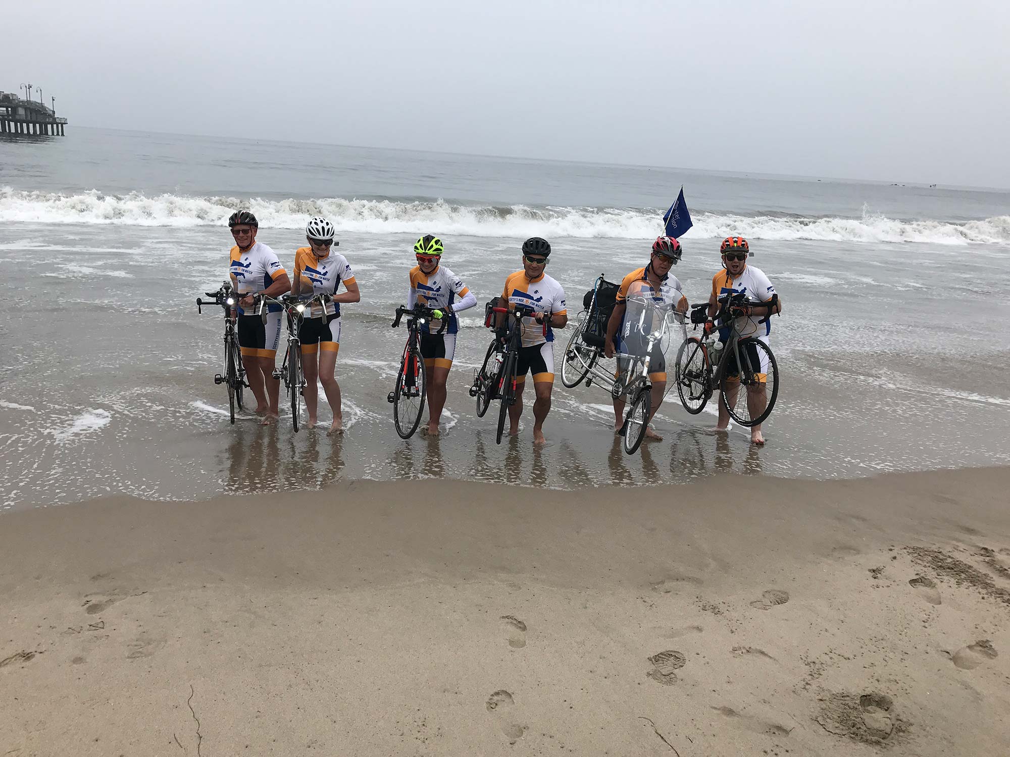 The Scotty's Ride team dips their bike tires in the pacific ocean before heading East.