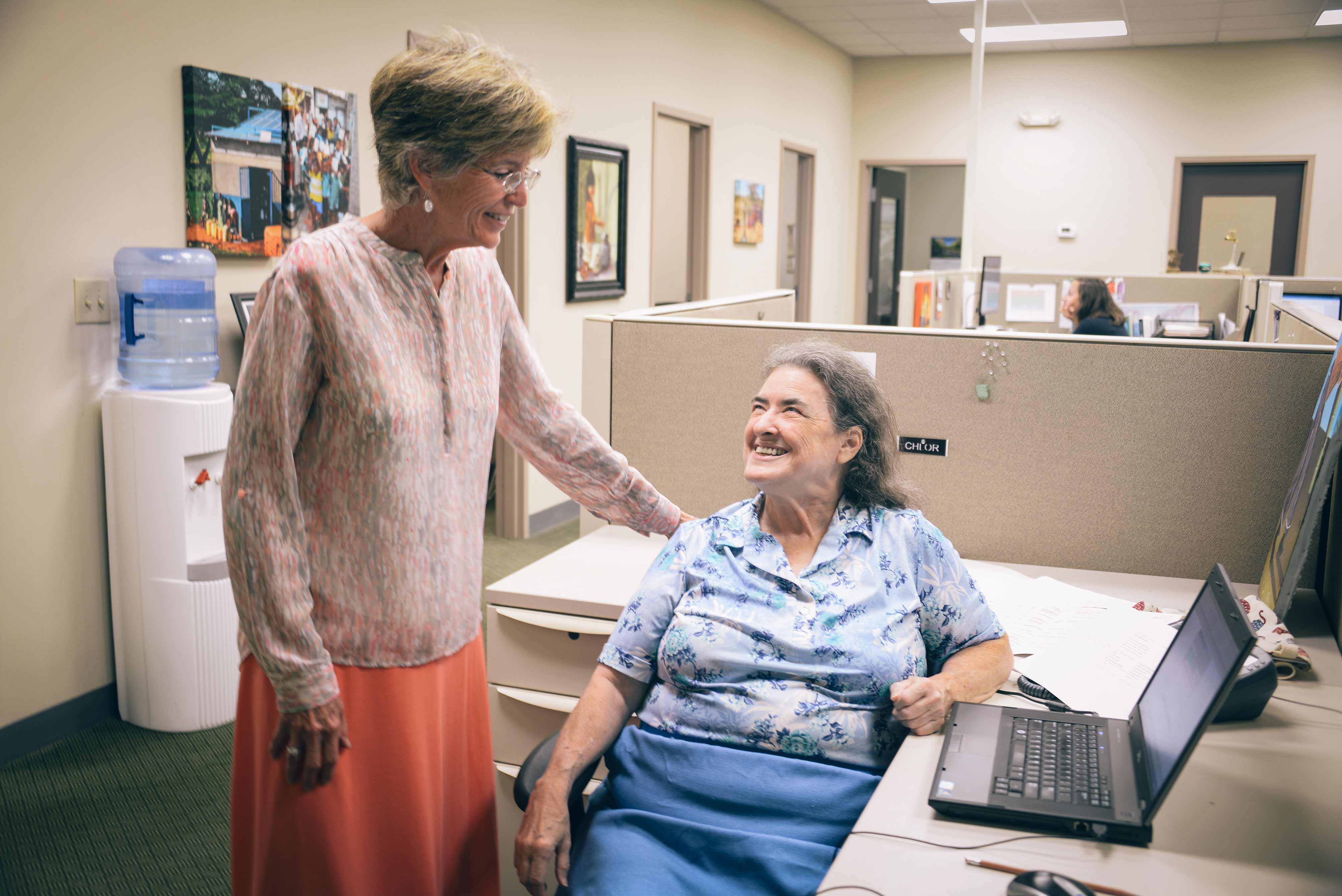 Cathy chats with Molly Greene, Co-Founder of Water Mission, at her desk in the office.