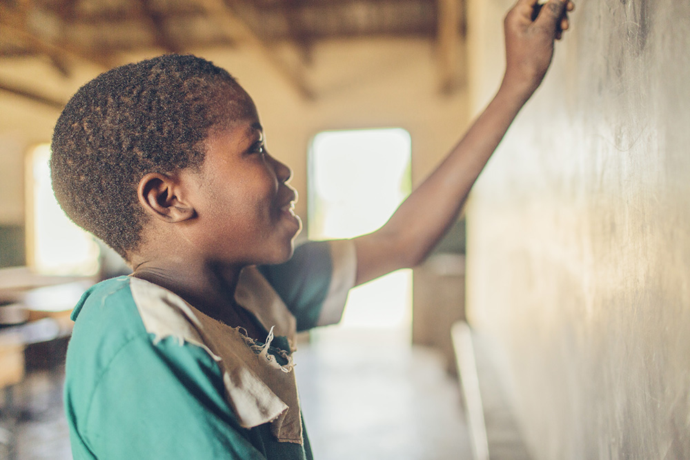 Dina works out a problem on the board at school.