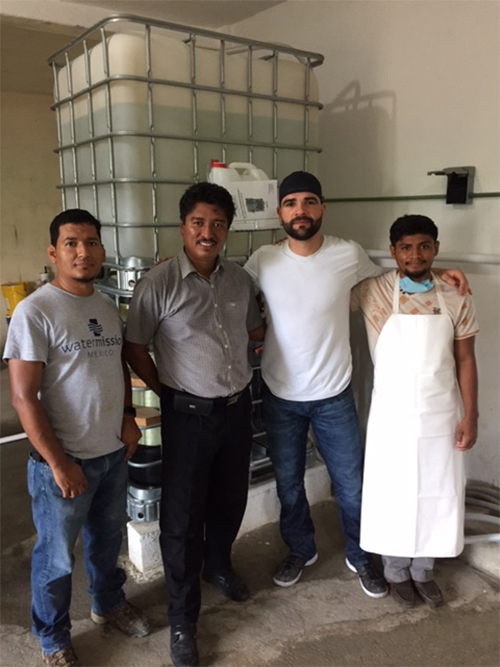 Jaime stands with Water Mission Mexico staff members at a safe water treatment system.