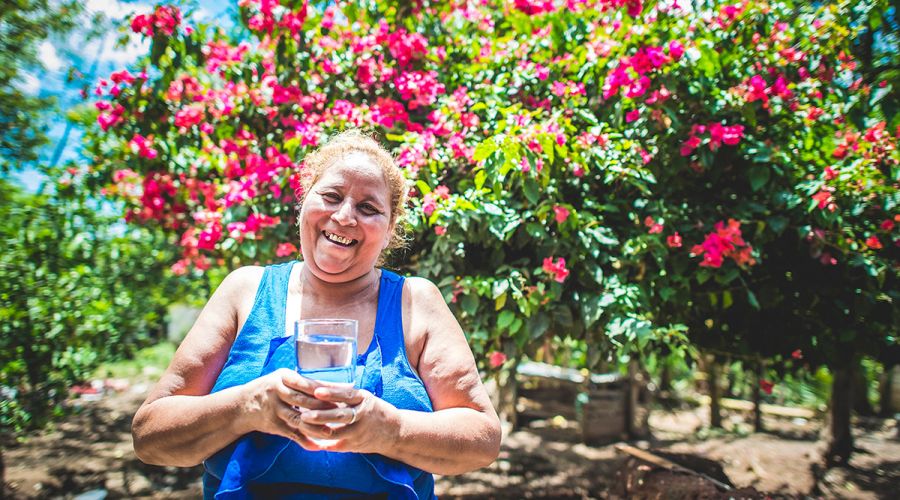 Felis drinks a cup of clean, safe water.