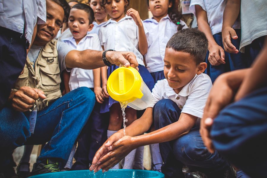 A young boy in Honduras washes his hands with safe water.