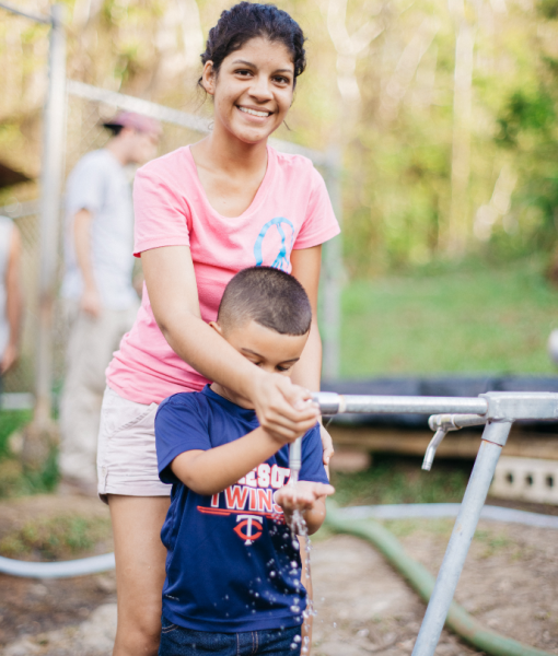 A mother and her son get safe water from the tap.