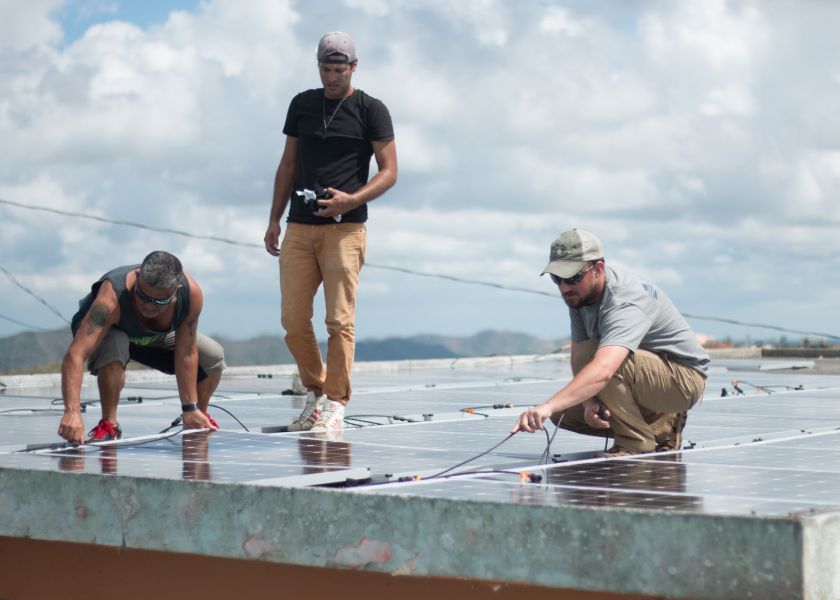 Tim Darms (Project Engineer) installs solar panels to power safe water systems.