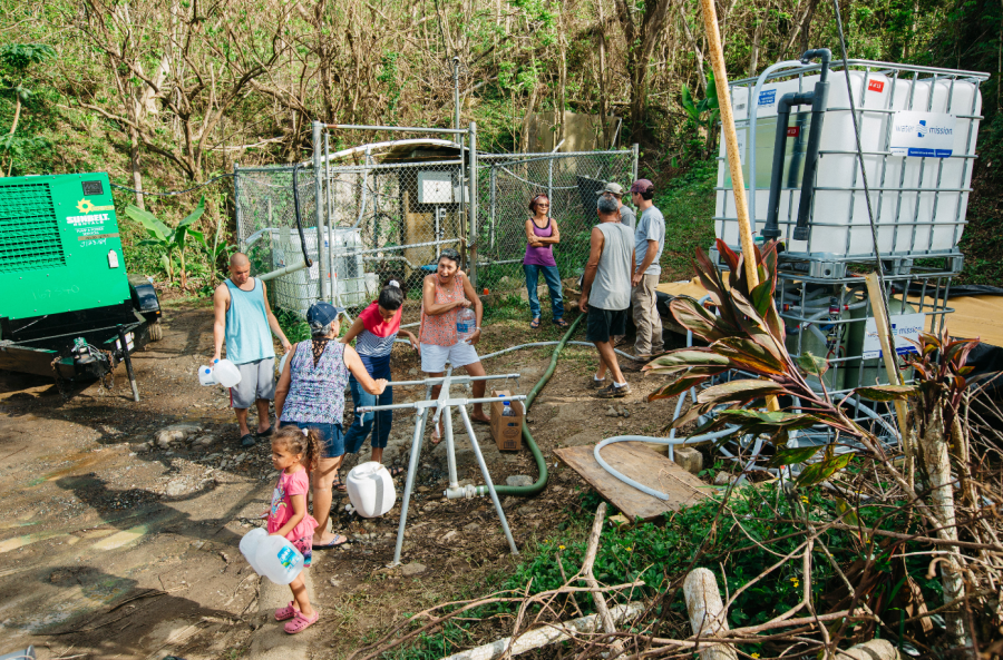 A community drinks safe water from the tap connected to a Water Mision's Living Water Treatment System.