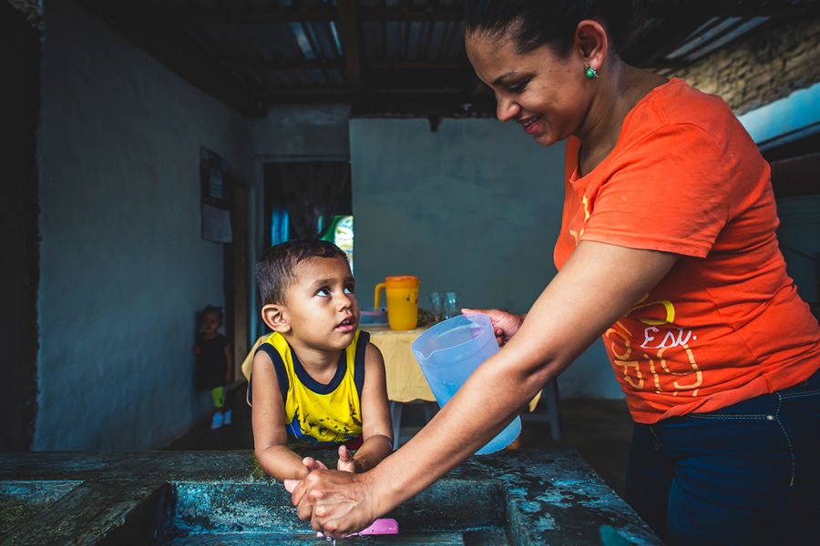 Ubelia's grandson washes his hands with safe water.