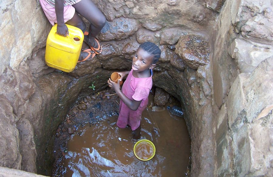 A young girl in Sierra Leone retrieves water from a well.