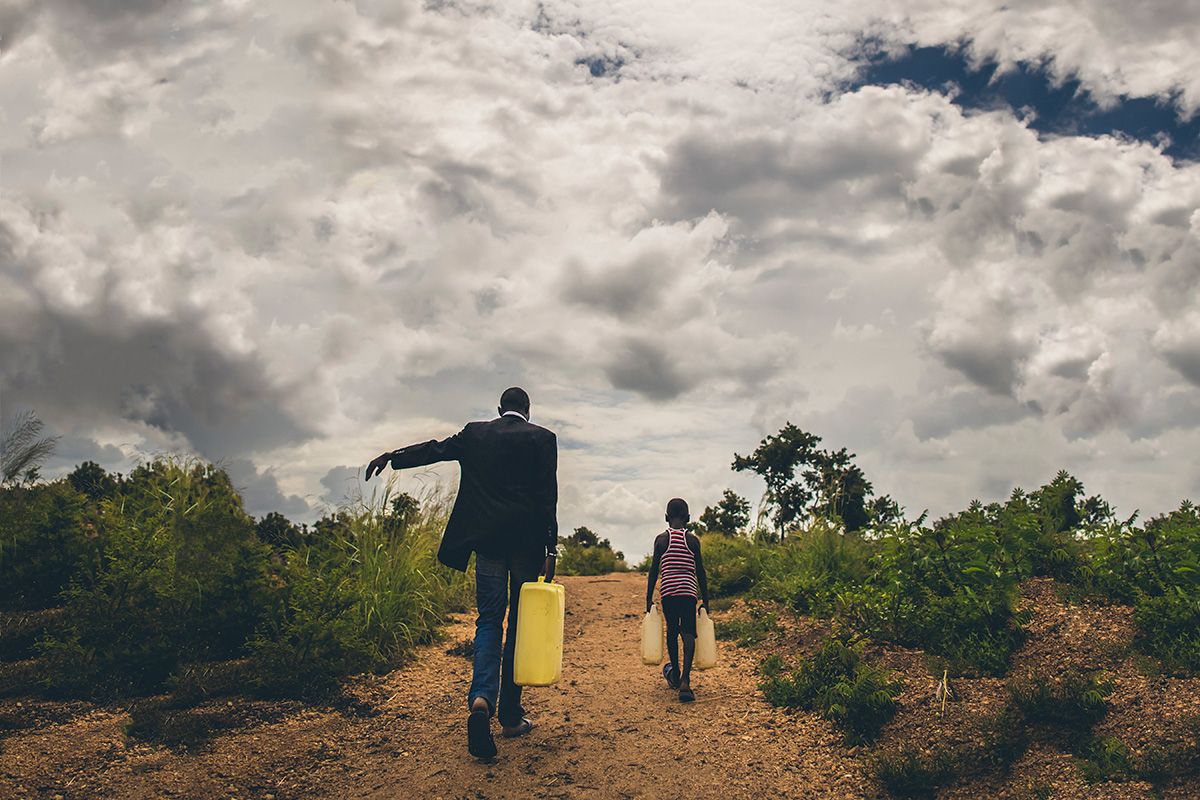 Dada Angelo collecting water with his youngest son