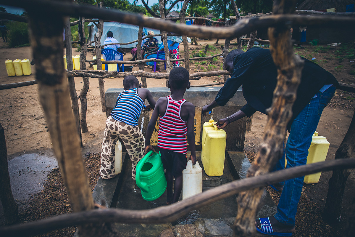 Dada Angelo and his sons at the Water Mission tap